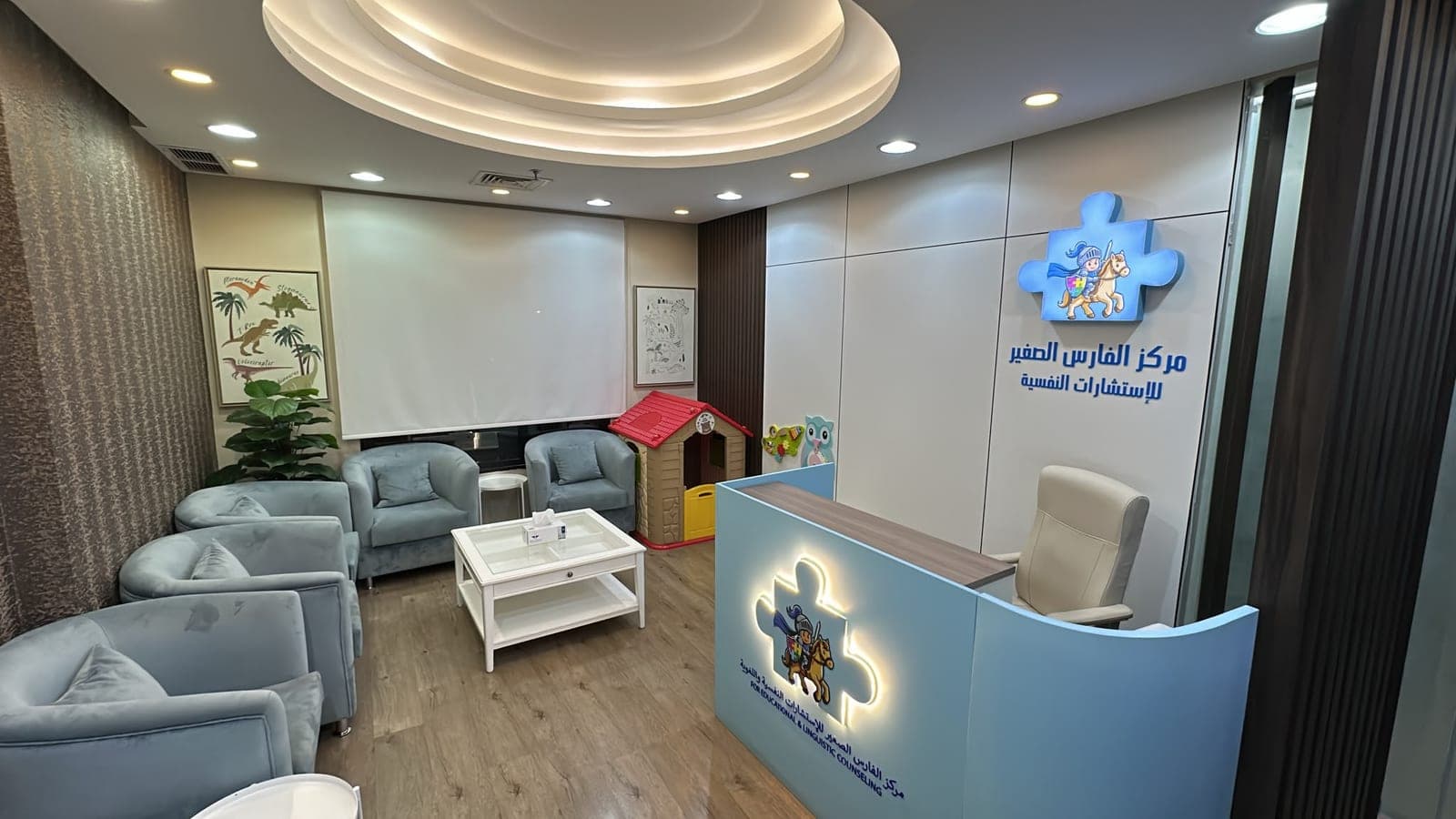 استقبال مركز الفارس الصغير: مقاعد انتظار مريحة وركن لعب للأطفال وشعار المركز على الحائط